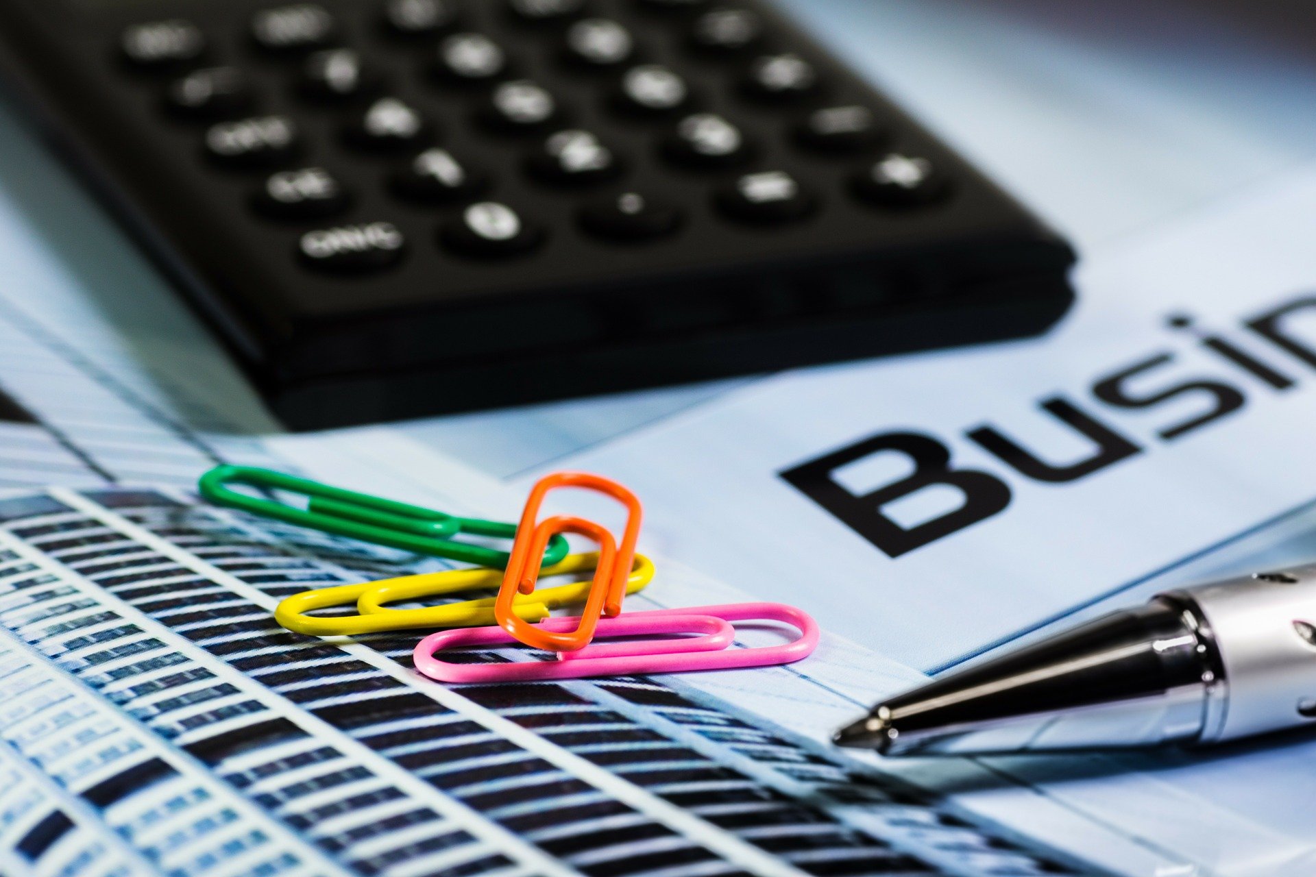 Calculator with paper clips and pen